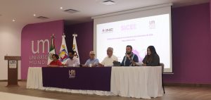 seis personas sentadas en una mesa frente a una pantalla de proyector