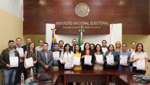 varias personas de pie sosteniendo reconocimientos