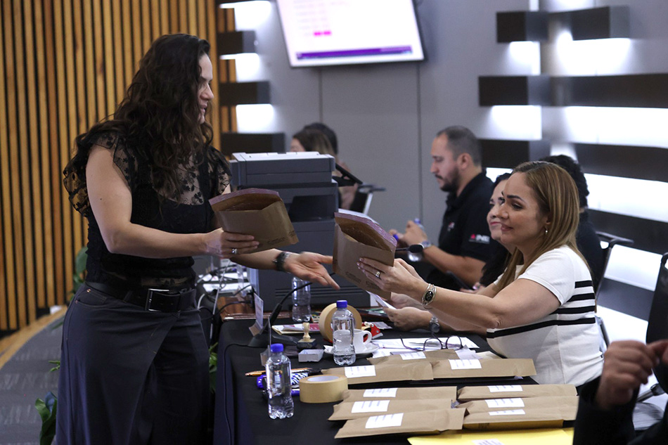 Mujeres intercambiando sobres con información del simulacro