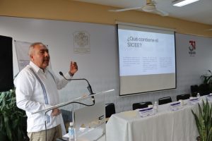 un hombre de pie frente a un micrófono delgado