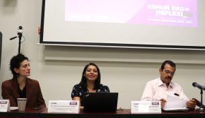 dos mujeres sentadas, a su lado un hombre leyendo