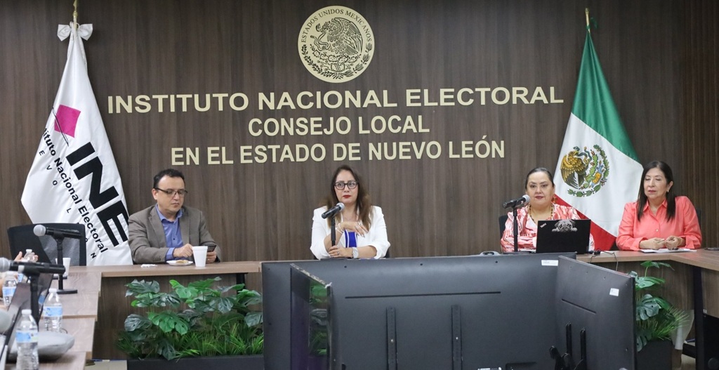 tres mujeres y un hombre en una reunión de trabajo
