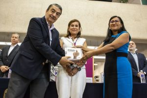 dos mujeres de pie recibiendo libros