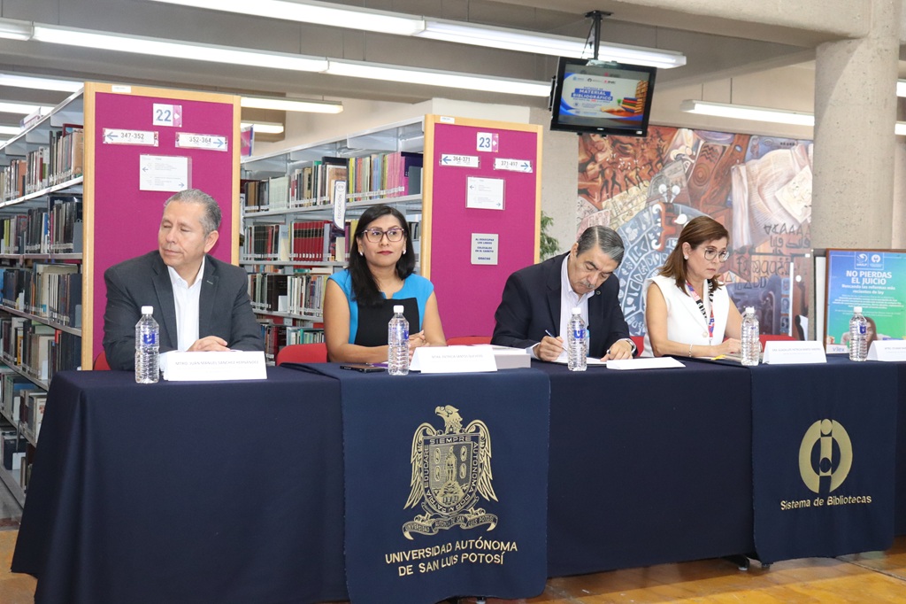 dos mujeres y dos hombres sentados frente a un a mesa con mantel color azul
