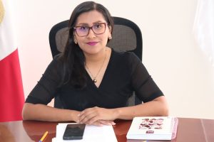 mujer sentada con brazos sobre la mesa