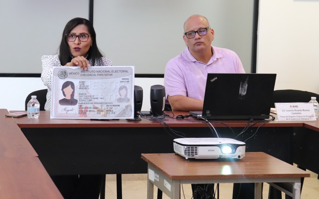 una mujer sosteniendo una credencial tamaño media cartulina