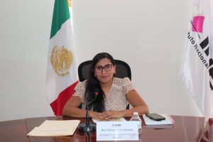 mujer sentada cabello largo hacia un lado y lentes