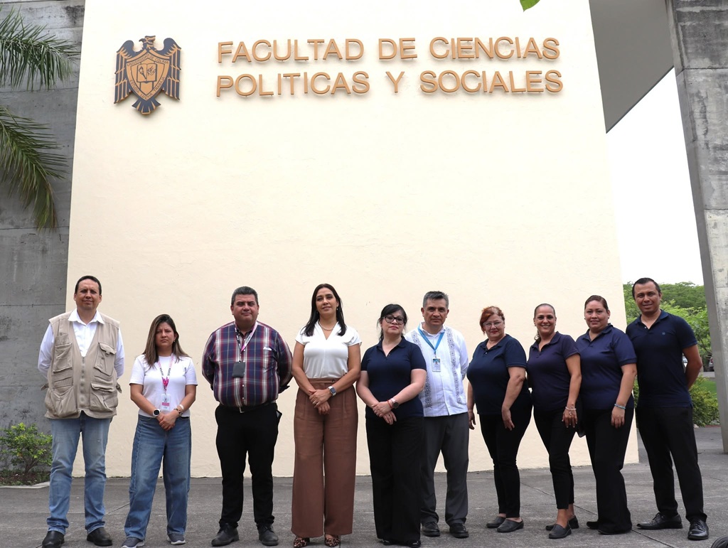 varias personas paradas bajo el letrero de una universidad