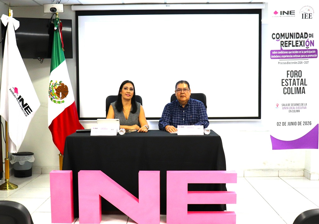 una mujer y un hombre están sentados y enfrente tres letras color rosa