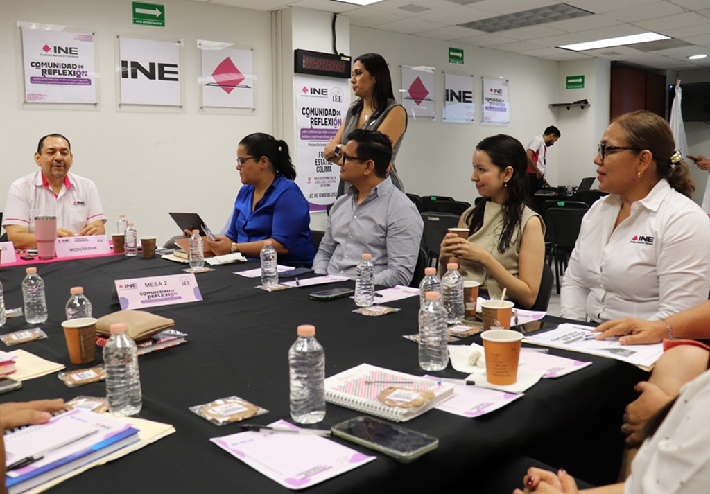 hombres y mujeres en una reunión de trabajo platicando