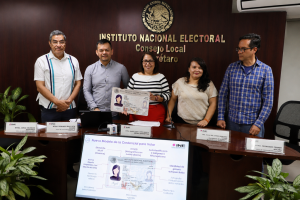 cinco personas de pie sosteniendo una credencial tamaño cartulina