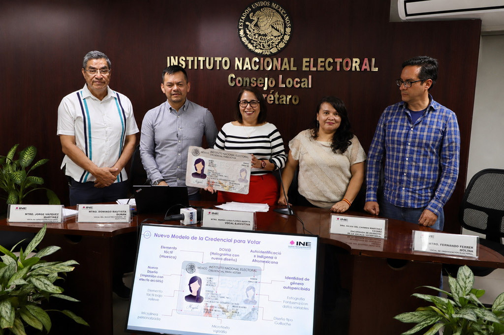 cinco personas de pie sosteniendo una credencial tamaño cartulina