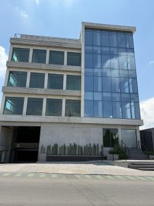 Edificio gris de tres pisos y ventanales