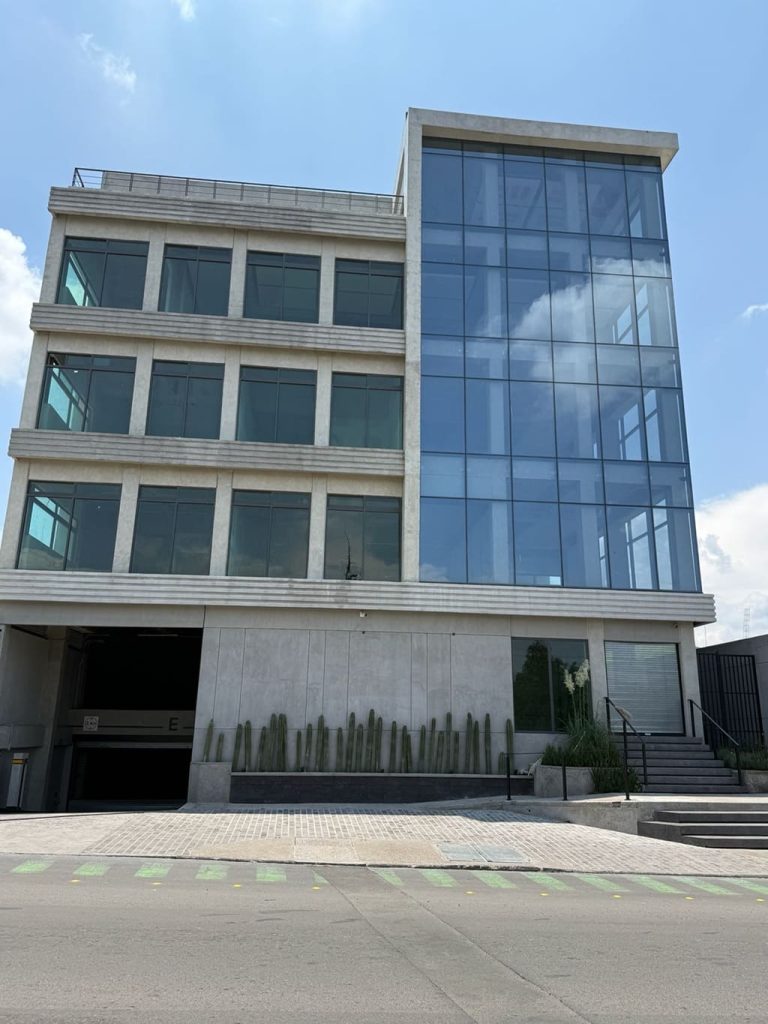 Edificio gris de tres pisos y ventanales