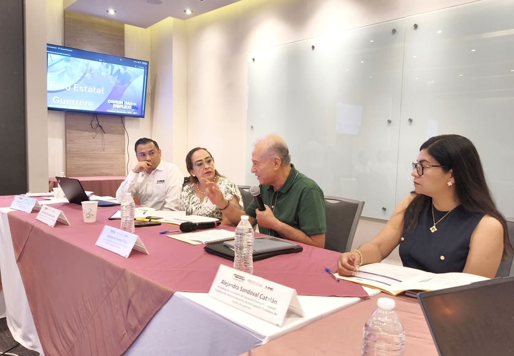 cuatro personas sentadas, un hombre habla