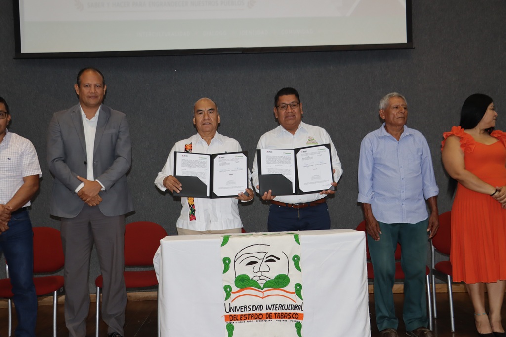 seis personas de pie para la fotografía oficial, dos sostienen un documento