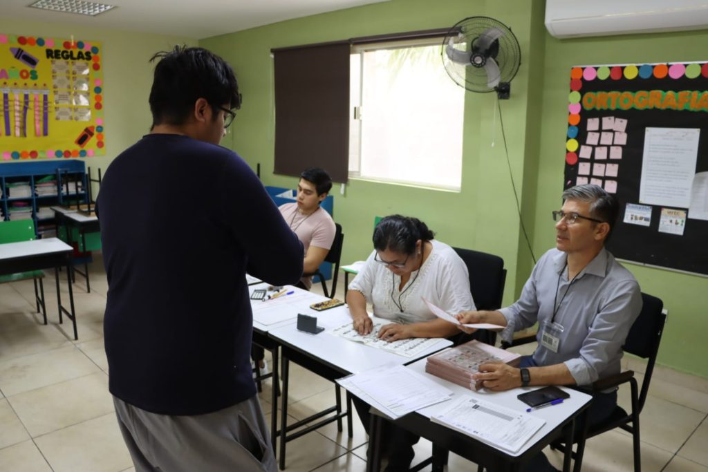 funcionario de casilla entregando boleta electoral a un ciudadano