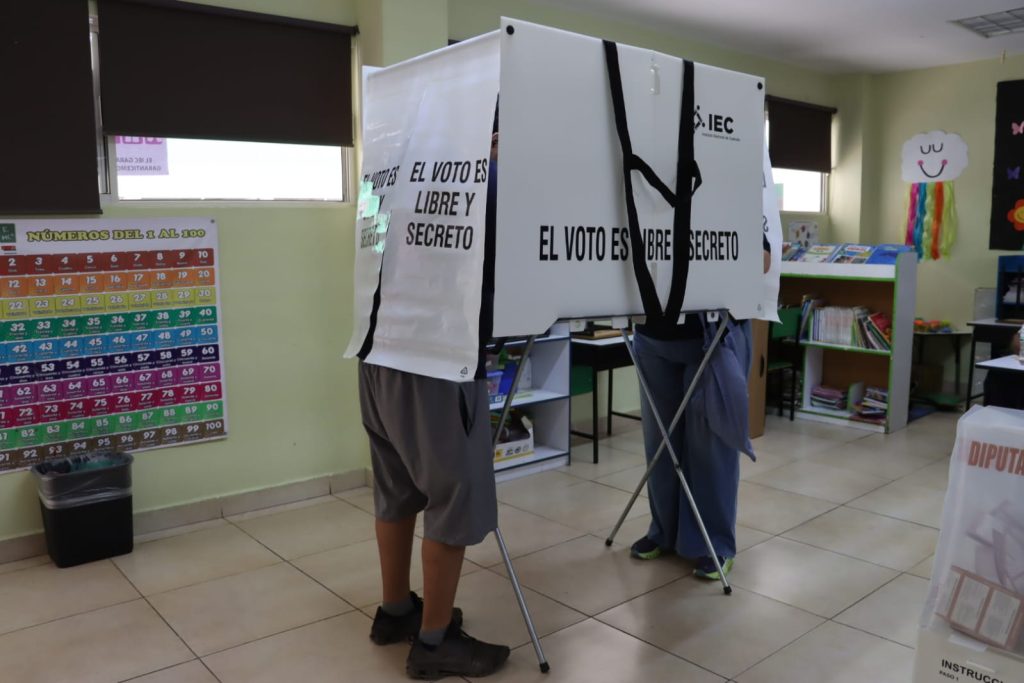 Personas ejerciendo su voto