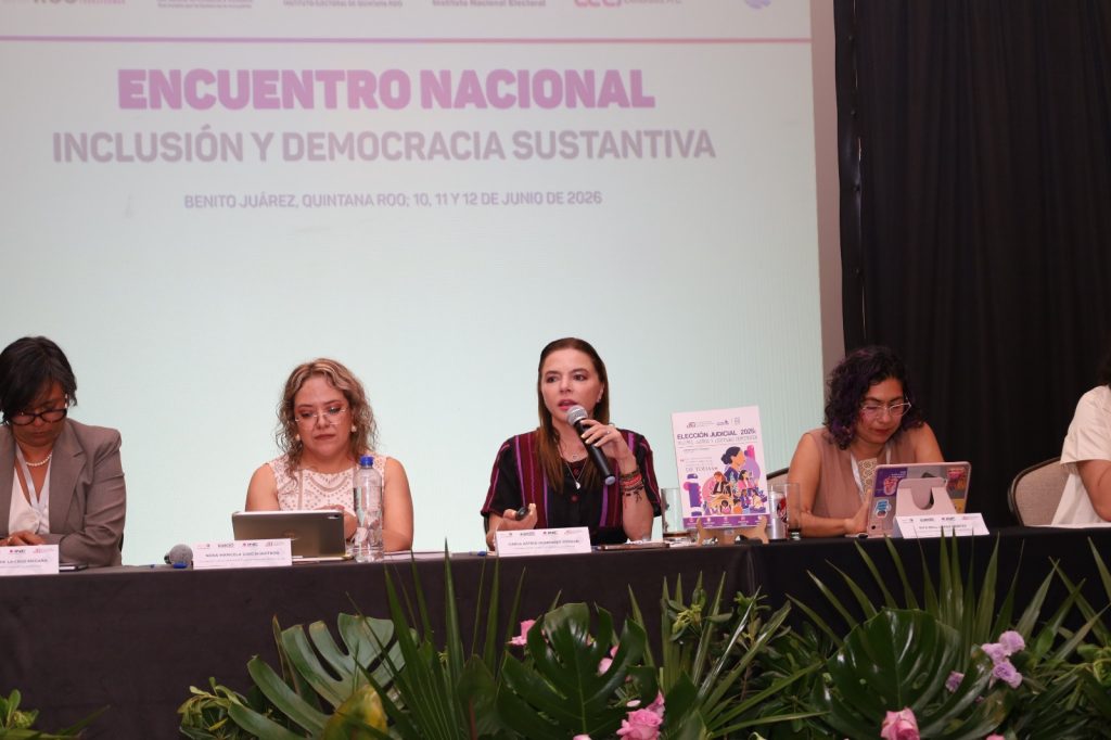 Personas participantes sentadas en el estrado.