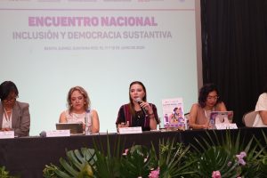 Personas participantes sentadas en el estrado.