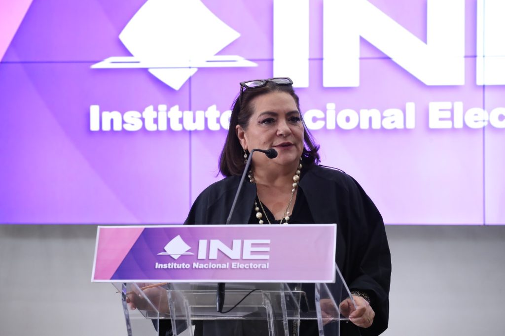 Guadalupe Taddei Zavala, Consejera Presidenta parada en el pódium participando en la conferencia.