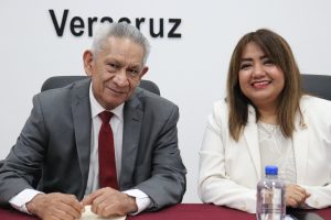 dos personas sentadas y sonriendo posando para la foto