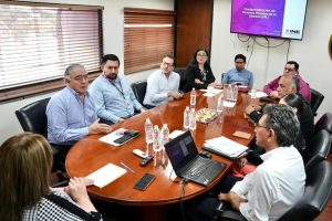 tres mujeres y siete hombres sentados mientras tienen una reunión