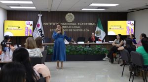Una mujer de pie hablando mediante un micrófono