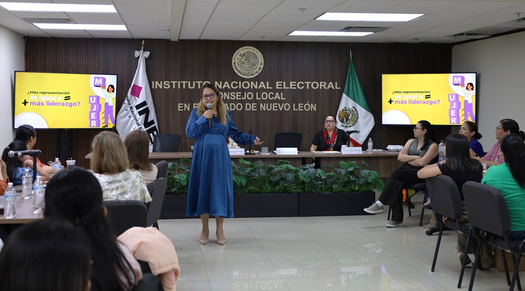 Una mujer de pie hablando mediante un micrófono