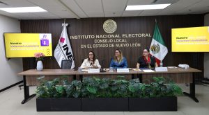 tres mujeres sentadas frente a una mesa con micrófonos
