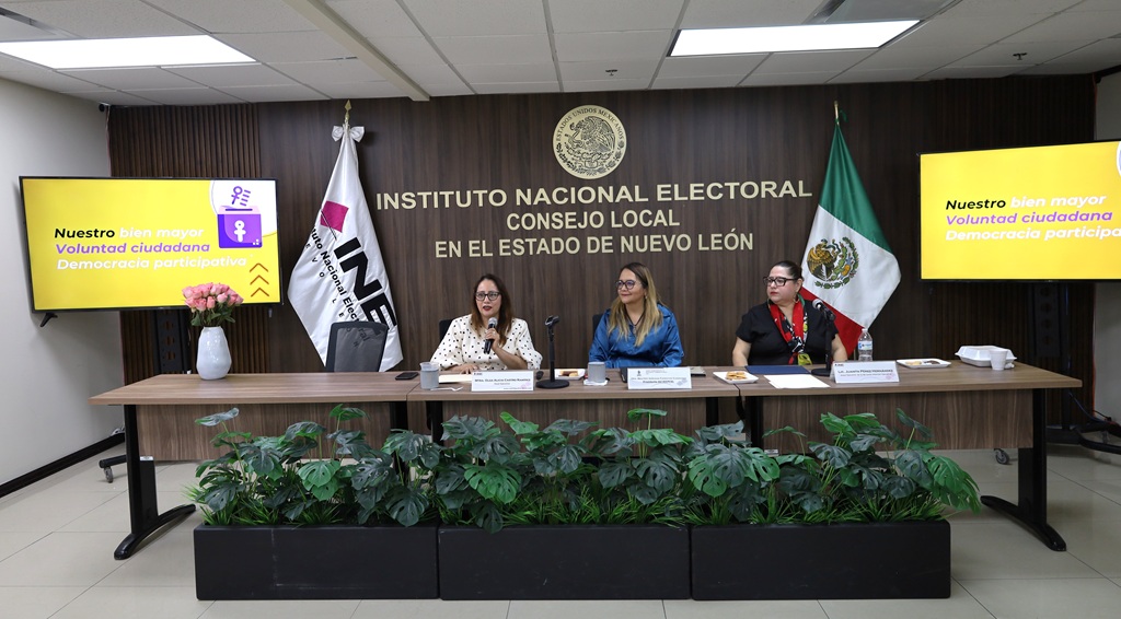 tres mujeres sentadas frente a una mesa con micrófonos