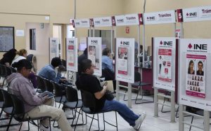 varias personas sentadas al interior de un módulo del INE