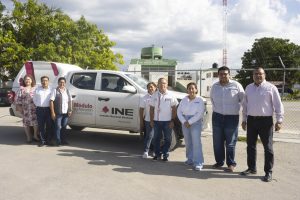 Personas funcionarias del INE en campeche de pie a un lado de camioneta blanca