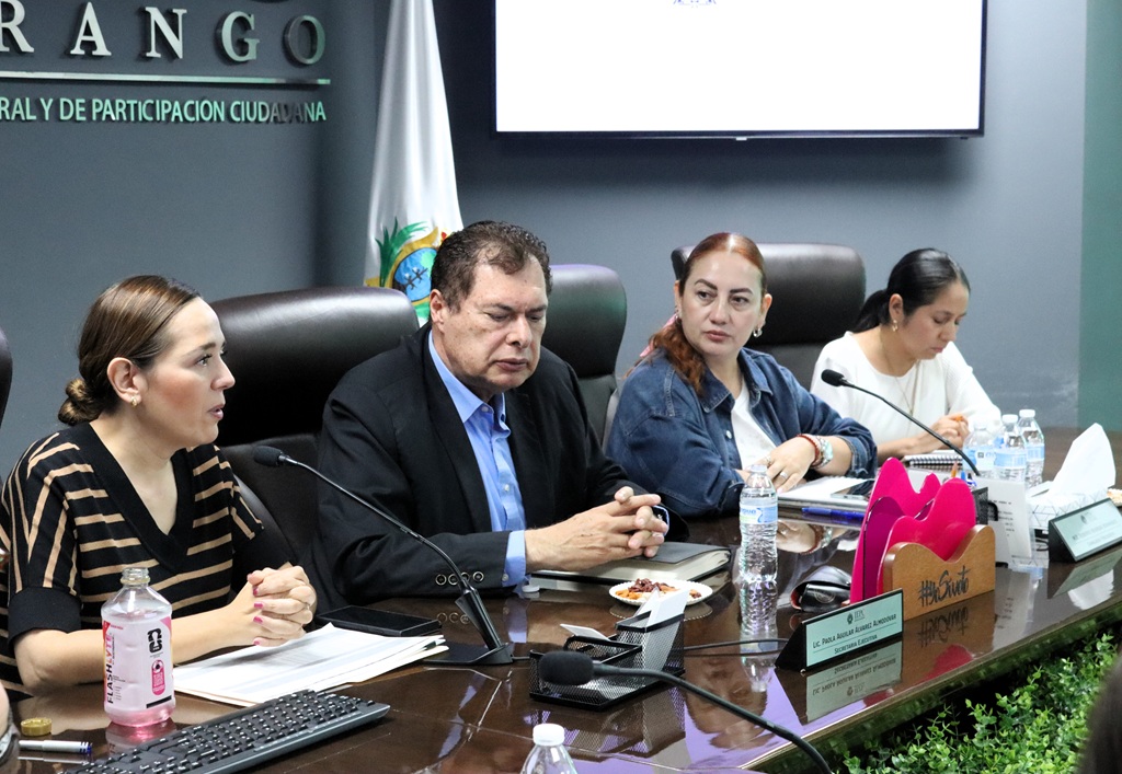 cuatro personas sentadas con brazos sobre la mesa