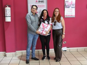 dos mujeres y un hombre de pie posando para la fotografía