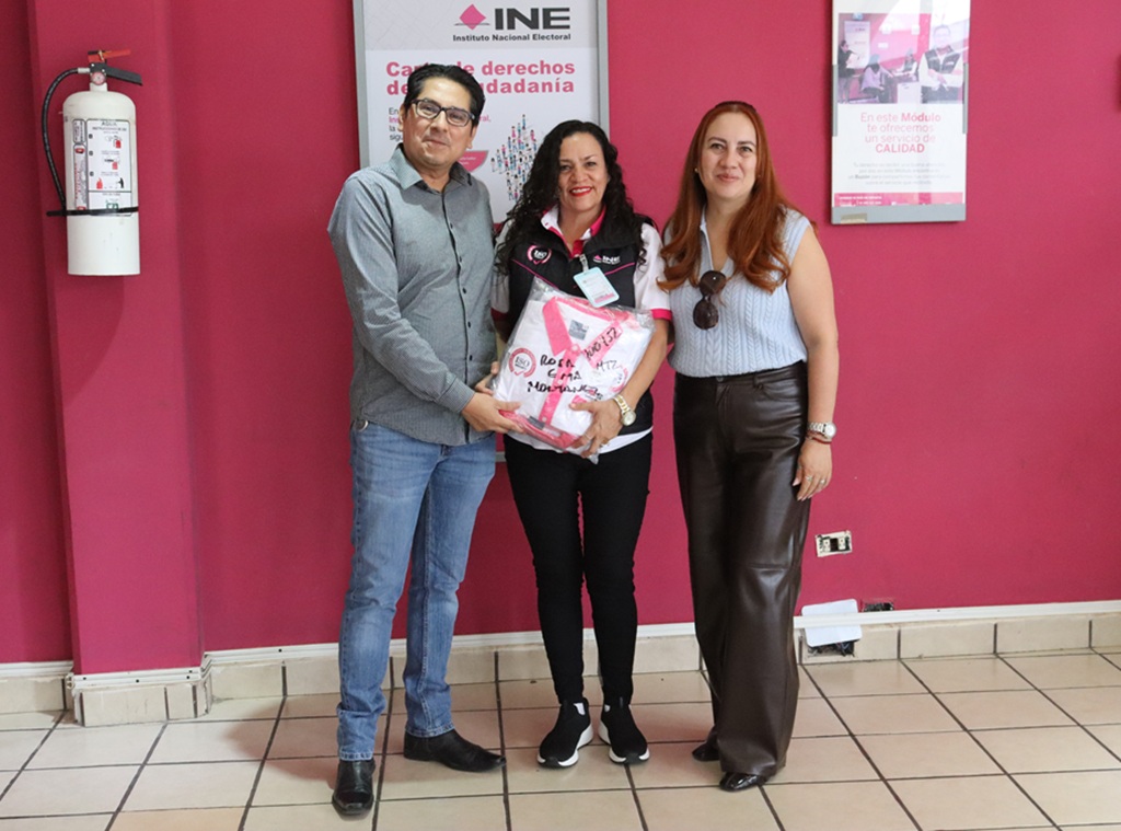 dos mujeres y un hombre de pie posando para la fotografía
