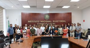 varias personas de pie en un salón posando para la foto oficial
