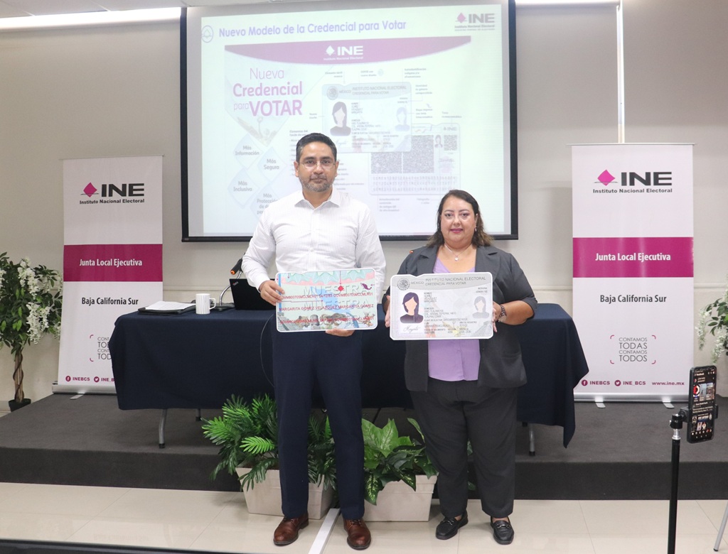 una mujer y un hombre de pie sosteniendo la imagen de la credencial para votar tamaño cartulina