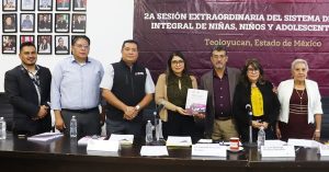tres mujeres y cuatro hombres de pie, posando para la foto oficial