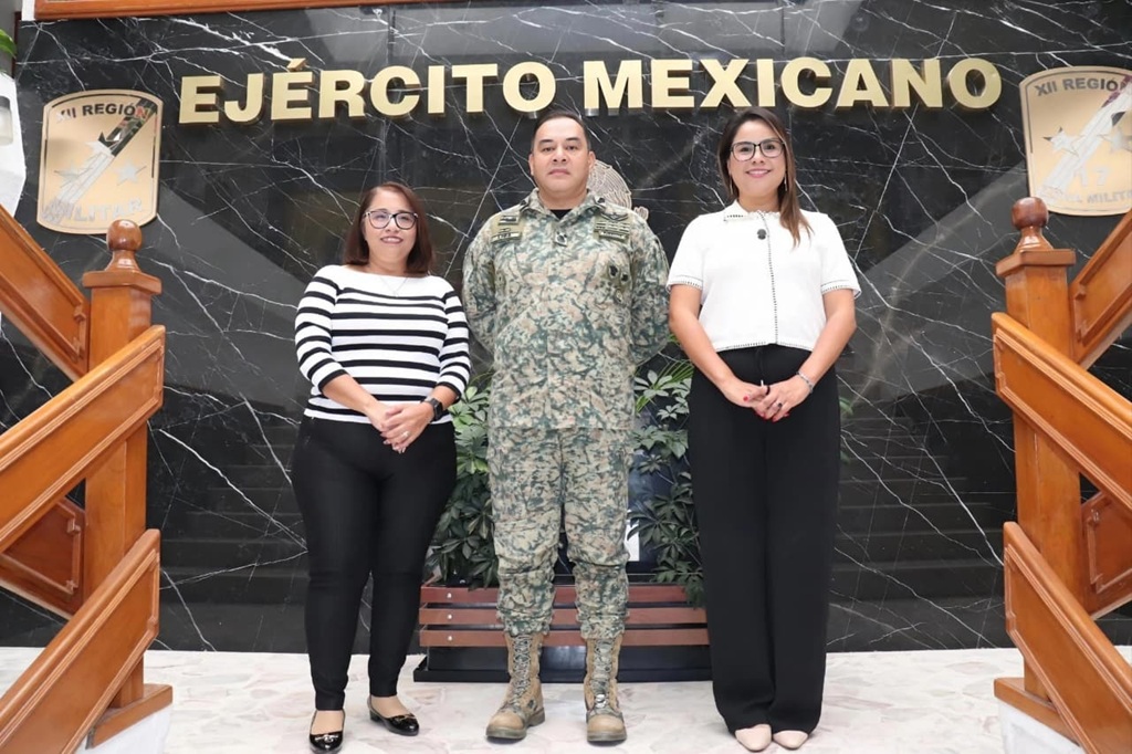 dos mujeres y un hombre militar de pie posando para la foto oficial