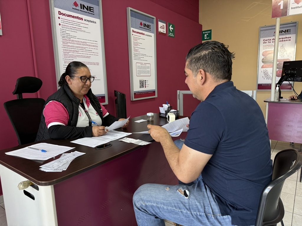 una persona asesorando a un ciudadano con el trámite de su credencial para votar