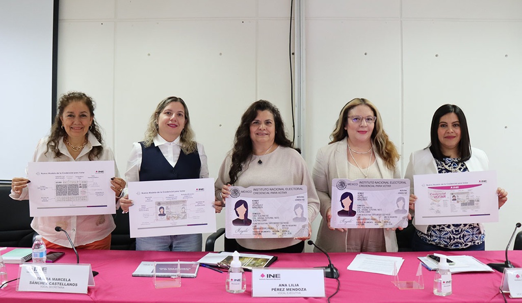 cinco mujeres de pie sosteniendo una credencial tamaño cartulina