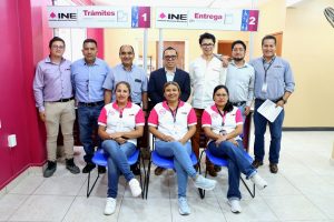 siete hombres de pie y frente a ellos tres mujeres sentadas