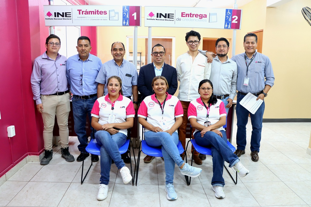 siete hombres de pie y frente a ellos tres mujeres sentadas