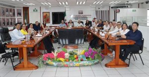 muchas personas sentadas alrededor de una mesa