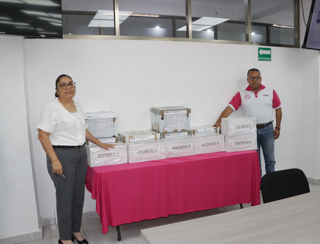 dos personas de pie en una mesa con cajas de cartón color blanco