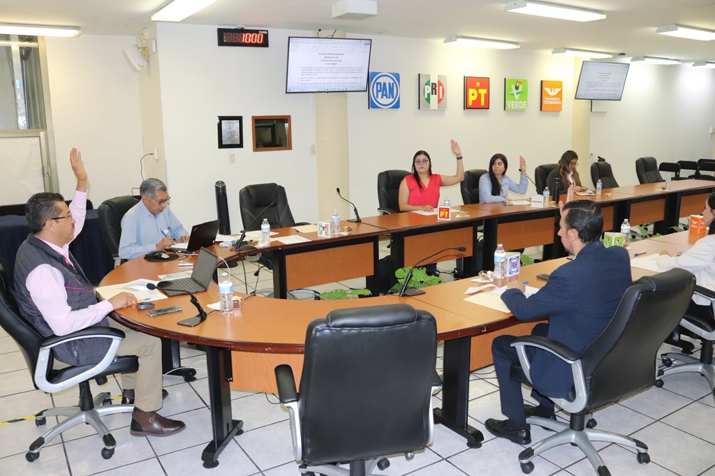 personas sentadas votando a mano alzada