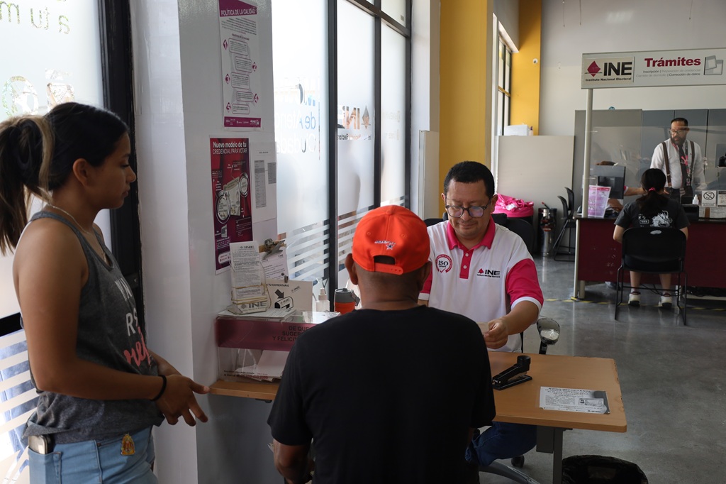 tres personas siendo atendidas en un módulo del INE