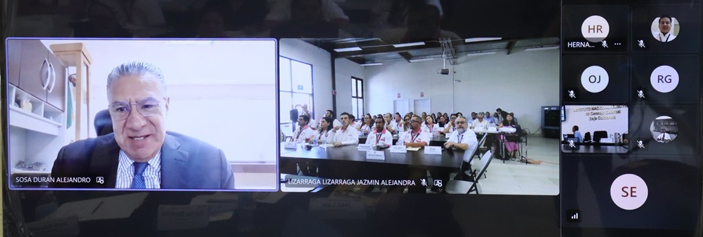 Un señor en una pantalla y a un lado otra pantalla con muchas personas
