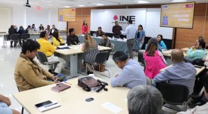 varias personas en un salón, en grupos de cinco
